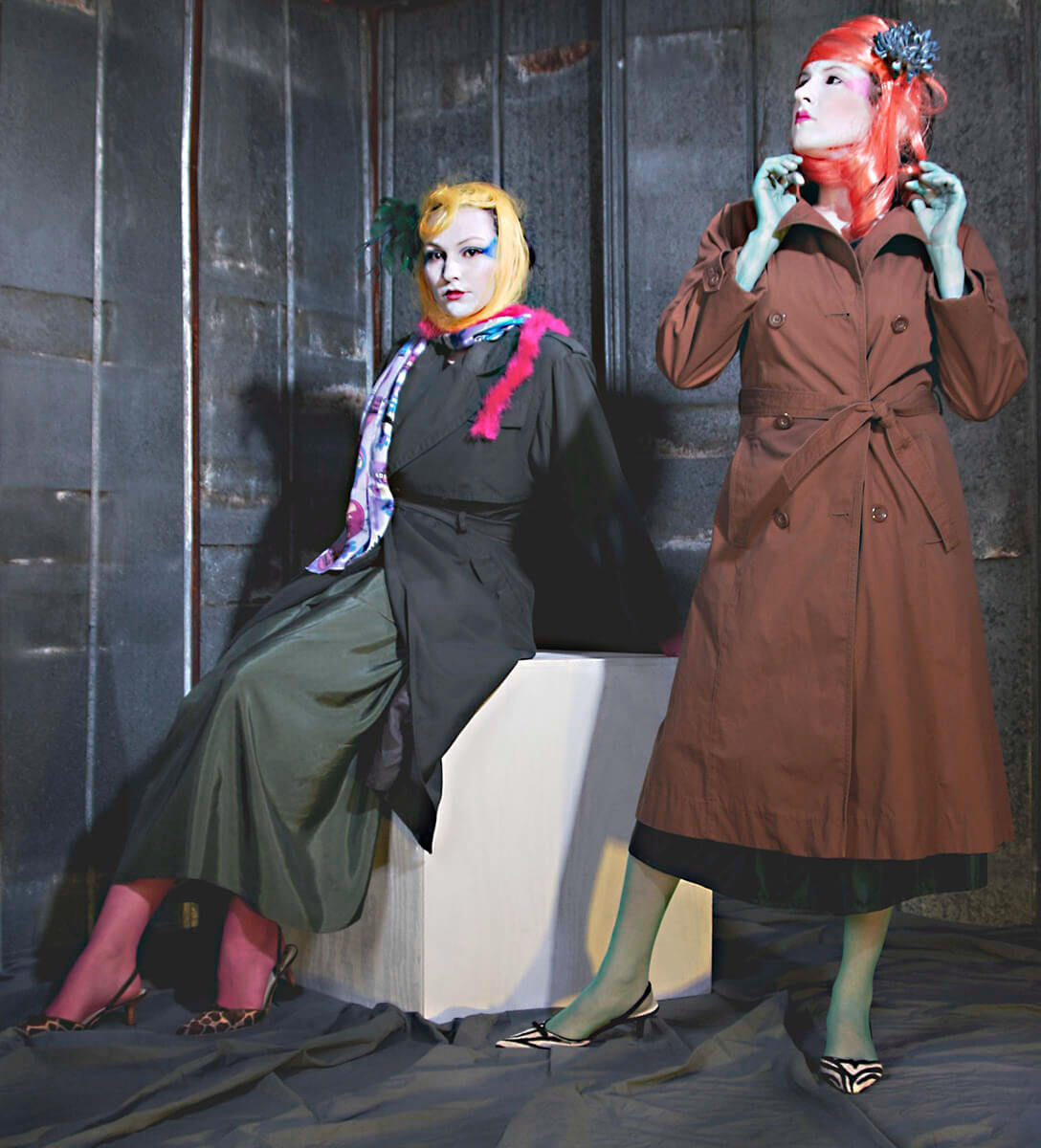 Avant-garde fashion duo in studio with dramatic lighting